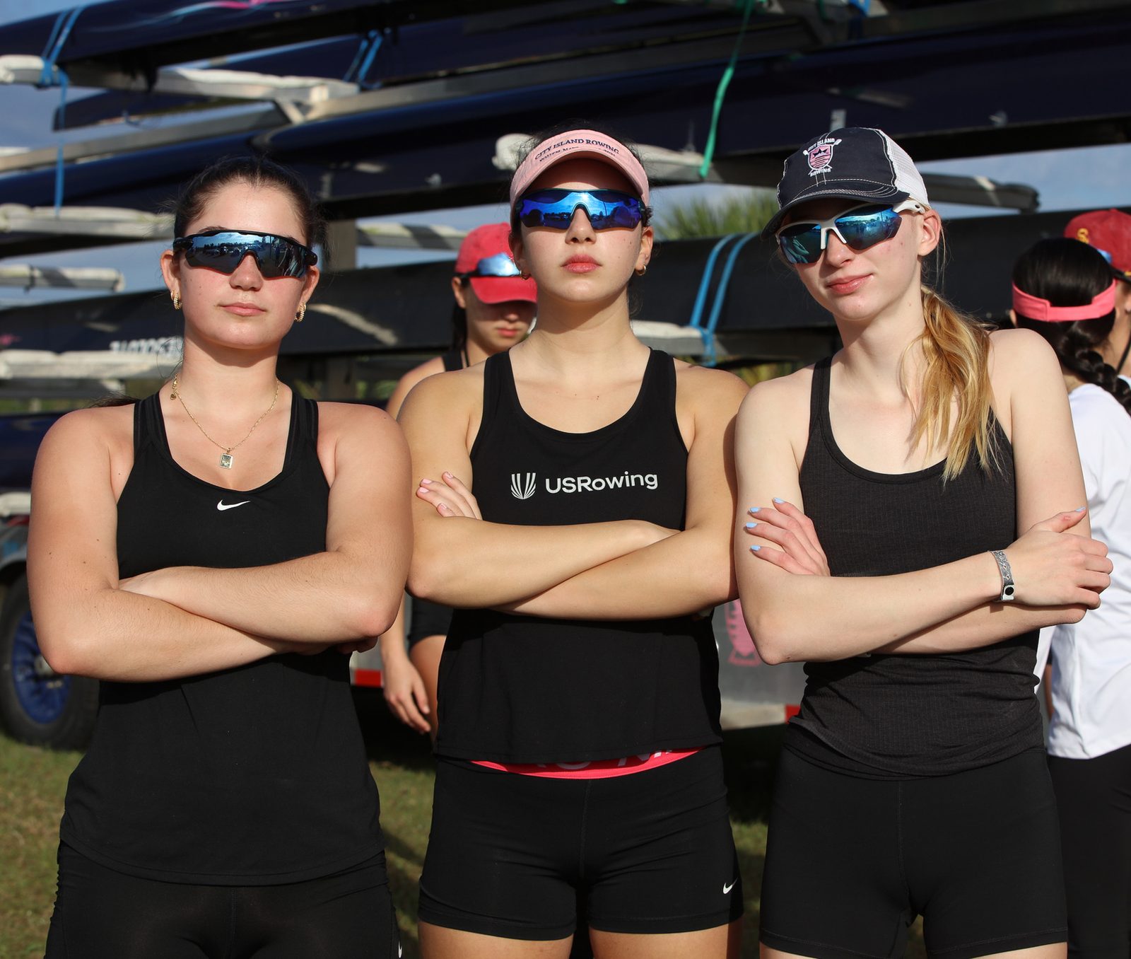 Three athletes, arms crossed, game faces on before racing