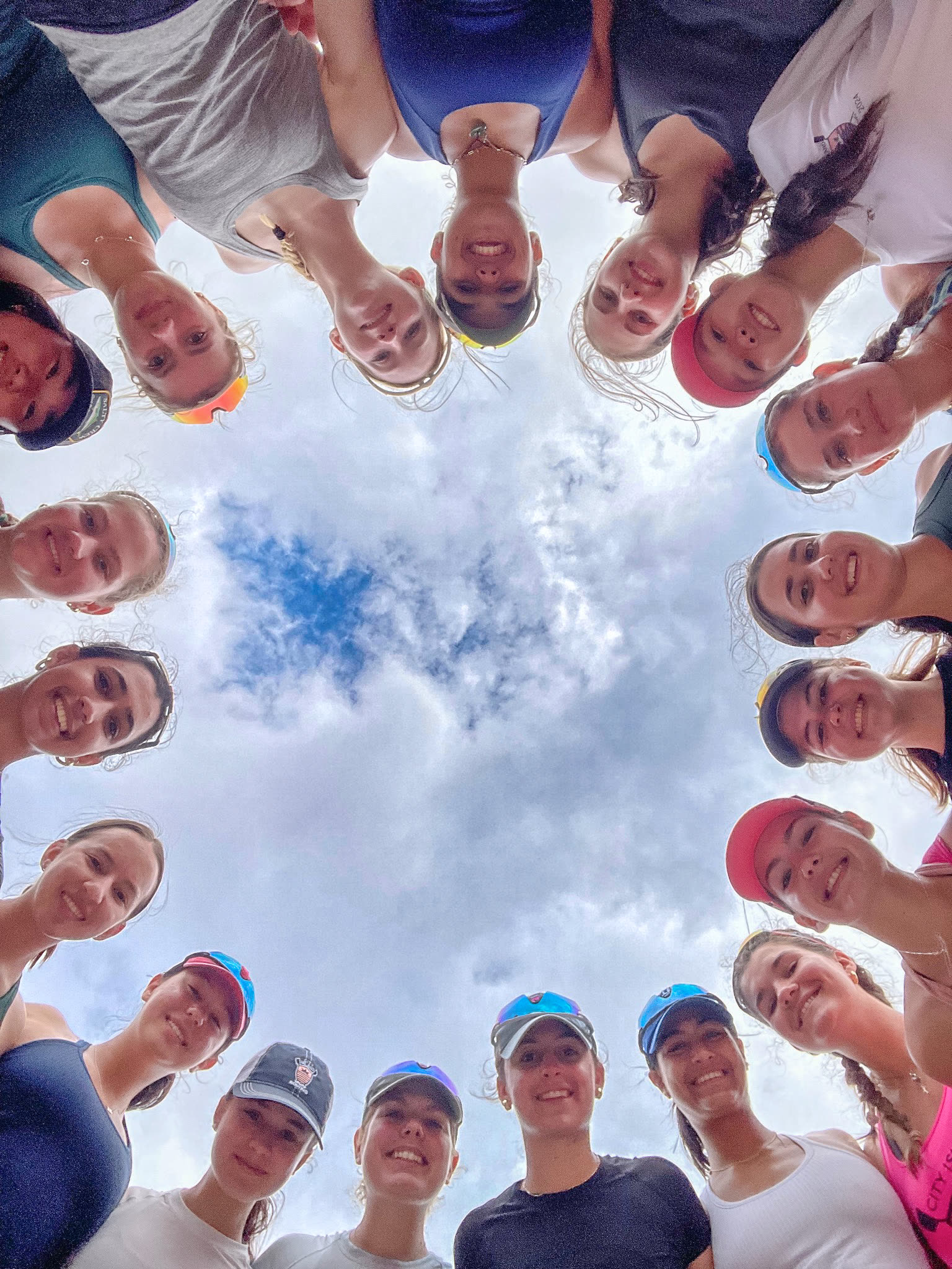Athletes in a circle looking down at the camera